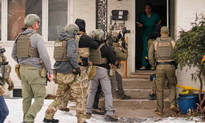 Các đặc vụ liên bang mang súng khi khám xét một ngôi nhà ở Minneapolis để bắt một người bị tình nghi nhập cư bất hợp pháp, ngày 11/1. Ảnh: AP