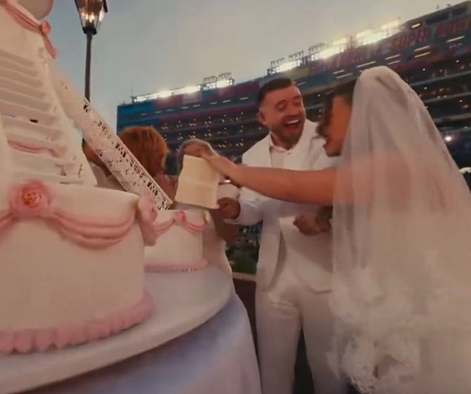 Đôi uyên ương cắt bánh cưới giữa sân cỏ vòng chung kết giải bóng bầu dục quốc gia. Ảnh: NBC