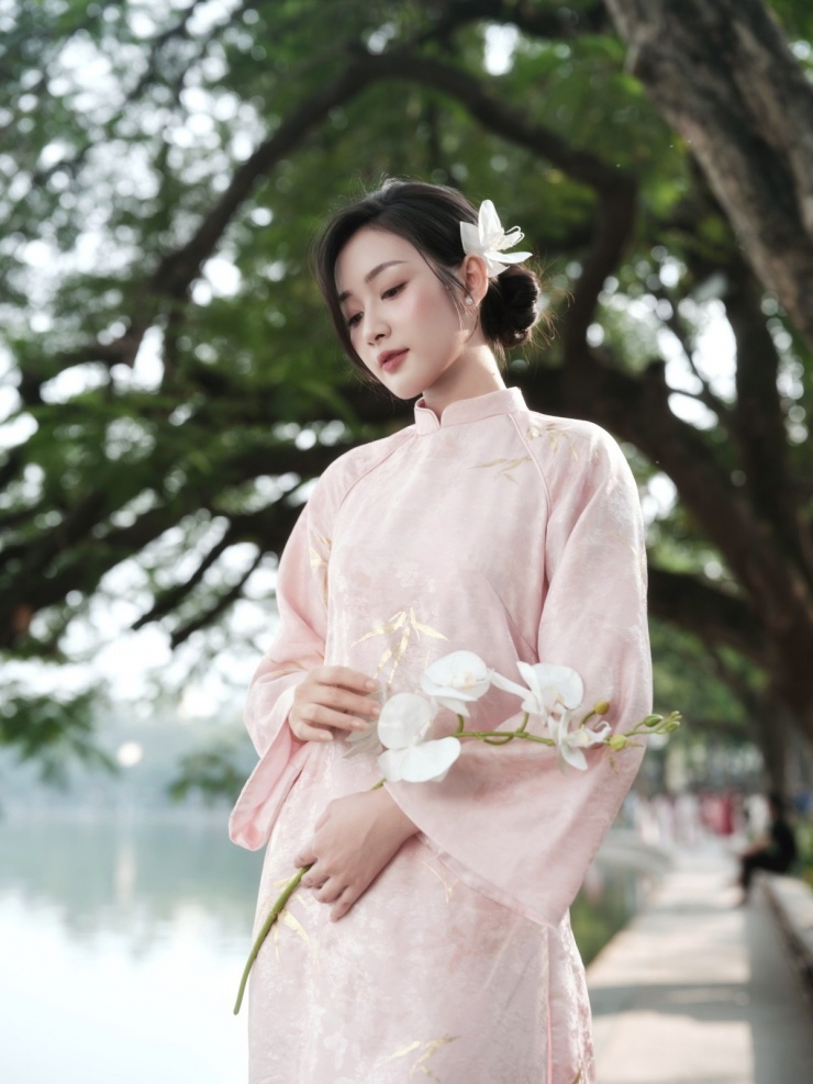 Hồ Gươm là một trong những địa điểm quen thuộc thu hút bạn trẻ chụp hình nhất. Từ tháng 12/2025, nơi đây đã trở nên đông đúc. Hương Giang, nhân viên văn phòng Hà Nội, nói: "Cuối tuần nào ở đây cũng đông người chụp áo dài. Tôi phải chờ hết đám này tới đám khác mới đến lượt chụp. Vì chỉ có vài góc đẹp mà ai cũng đứng vào đó". Ảnh: Gạo Nâu