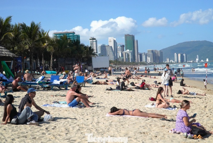 Bãi cát cũng đông nghịt khách nằm, ngồi phơi nắng. Ông Matthew (du khách Mỹ) cho hay đang lưu trú tại một khách sạn trên tuyến đường Võ Nguyên Giáp, ông cùng vợ đi bộ ra biển từ 12 giờ trưa và nằm thư giãn trên bãi cát. "Không khí, thời tiết ở đây thật tuyệt, chúng tôi cứ nằm nghỉ ngơi và đợi đến giữa chiều sẽ xuống tắm", nam du khách nói.