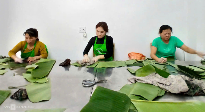 Nữ sinh Lê Thị Huyền (giữa) tranh thủ dịp nghỉ học về quê đã xin đi lau lá chuối cho cửa hàng nem kiếm thêm thu nhập. Ảnh: Lường Toán