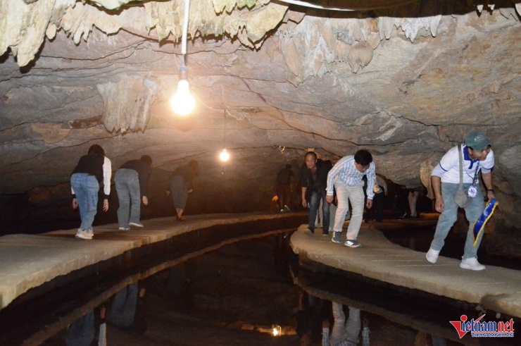 Du khách tham quan động Tiên Cá sẽ đi bộ trên cây cầu nổi uốn lượn trong lòng núi đá 