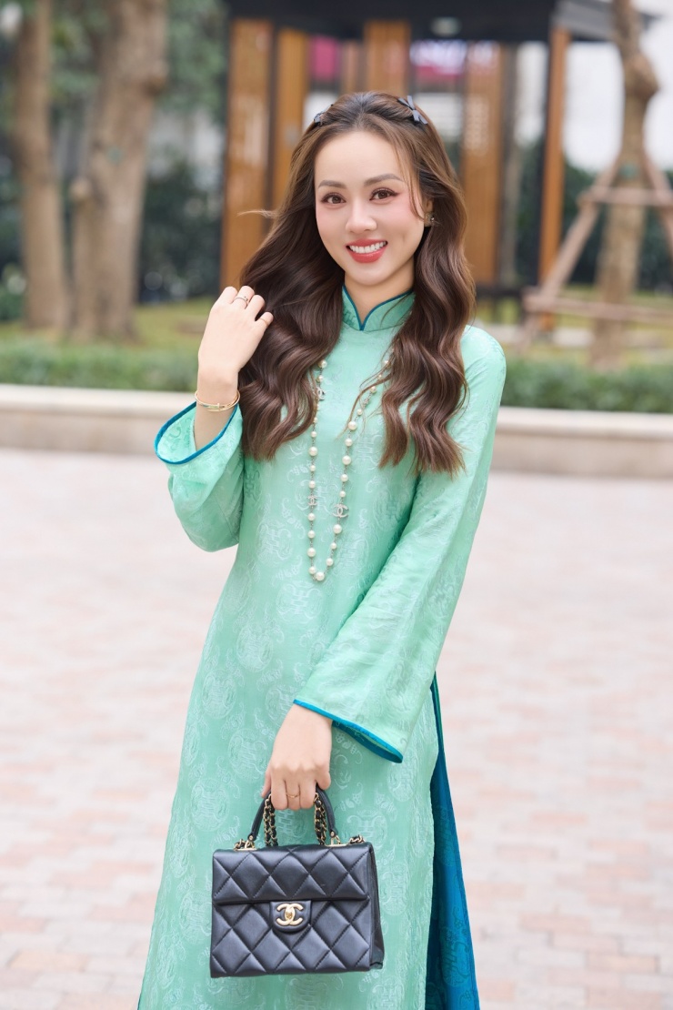 Bà xã NSND Công Lý mix áo dài khoe sắc bên chồng dịp Tết 11 Với mẫu áo dài tông xanh ngọc, Ngọc Hà chọn chiếc túi Chanel giá khoảng gần 200 triệu đồng.