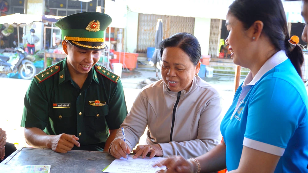 Bà Lê Thị Thoa ký cam kết chấp hành tốt các quy định pháp luật. Tiếng loa Biên phòng 1.jpg