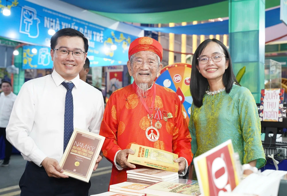 Nhà nghiên cứu Nguyễn Đình Tư (106 tuổi, đứng giữa), hào hứng tham quan các gian hàng tại Lễ hội Đường sách Tết Bính Ngọ 2026. đường sách tết (1).jpg