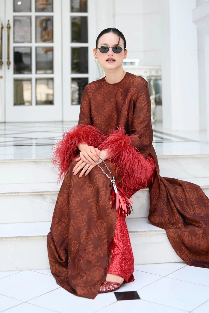 Mốt áo dài du xuân năm Ngựa 10 Tuyết Lan hưởng ứng xu hướng áo dài đính lông vũ, phối quần sequin trong thiết kế của Adrian Anh Tuấn. Cô dùng cặp kính tròn để tạo vẻ hoài cổ.