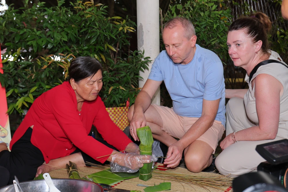 Khách quốc tế trải nghiệm gói bánh tét ở Việt Nam. Ảnh: THU TRINH. H6II9936.JPG