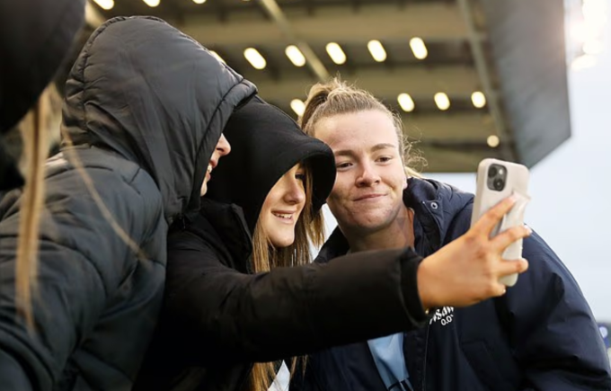 Lauren Hemp của đội nữ Man City chụp ảnh cùng người hâm mộ sau trận đấu gặp Everton trên sân Joie. Ảnh: WSL