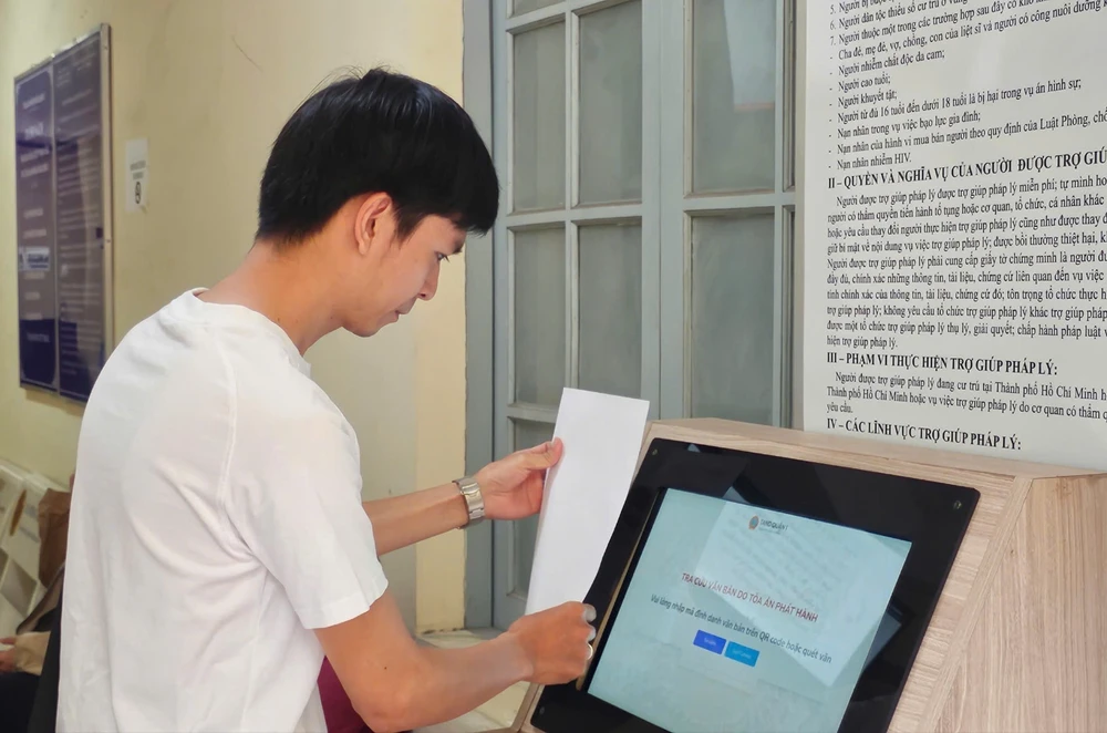 Người dân quét mã định danh trên văn bản để đối chiếu văn bản phát hành với văn bản gốc đã được lưu trong hệ thống, tránh giả mạo. Ảnh: SONG MAI