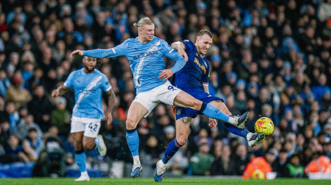 Erling Haaland (trái) tranh chấp bóng với Dan Burn. Ảnh: Man City