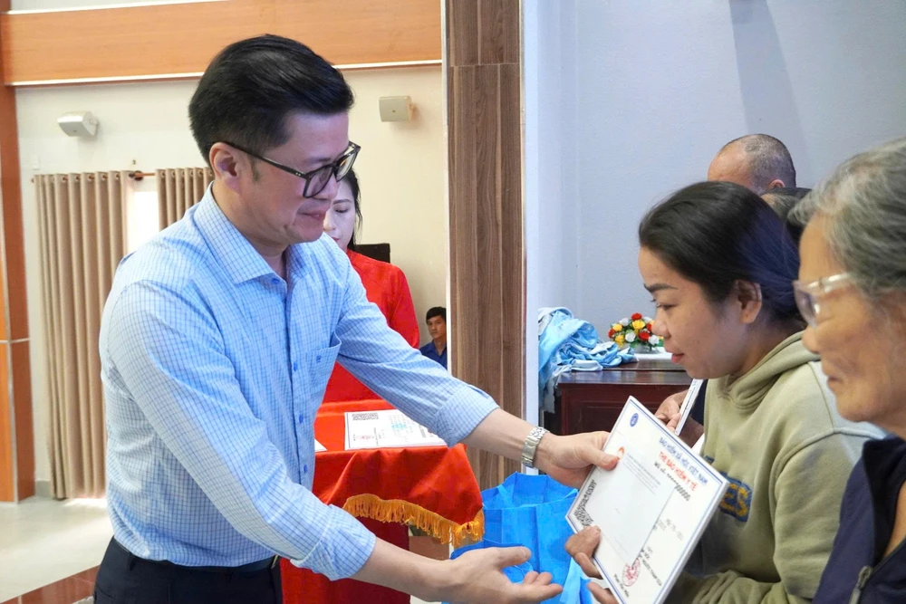 Ông Lò Quân Hiệp - giám đốc BHXH TP.HCM trao tặng thẻ BHYT cho người dân có hoàn cảnh khó khăn. bhxh-tp-hcm-tru-cot-an-sinh-cua-do-thi-hon-14-trieu-dan.png