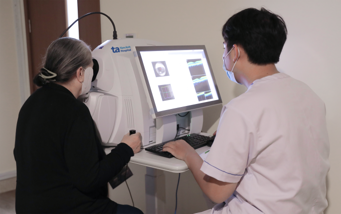 Kỹ thuật viên tắt đèn giúp kiểm tra chính xác cấu trúc vi mô mắt cho bà Mai. Ảnh: Bệnh viện Đa khoa Tâm Anh