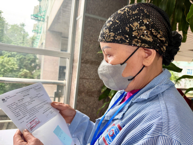 Bà Mai cầm trên tay giấy xuất viện, chính thức kết thúc điều trị, về quê đón Tết. Ảnh: Lê Nga