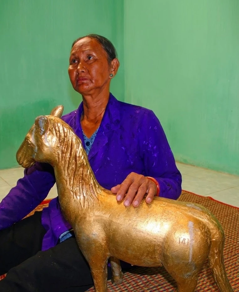 Bà Bảy cùng bức tượng ngựa vàng đào được. Ảnh: NAM PHƯƠNG