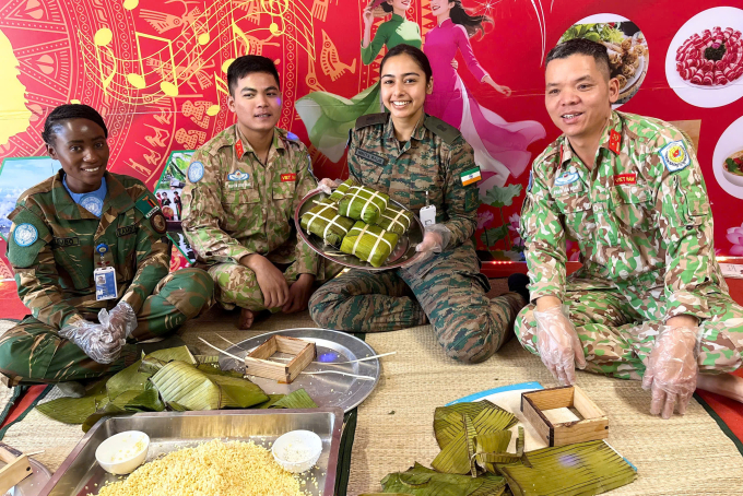 Lực lượng gìn giữ hòa bình Việt Nam hướng dẫn sĩ quan Ấn Độ, Zambia làm bánh chưng. Ảnh: Hải Yến