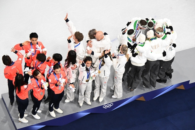 Các VĐV Mỹ (giữa), Nhật Bản (trái) và Italy (phải) trên bục nhận giải nội dung trượt băng đồng đội, ở nhà thi đấu Trượt băng Milano, Italy hôm 10/2. Ảnh: Reuters