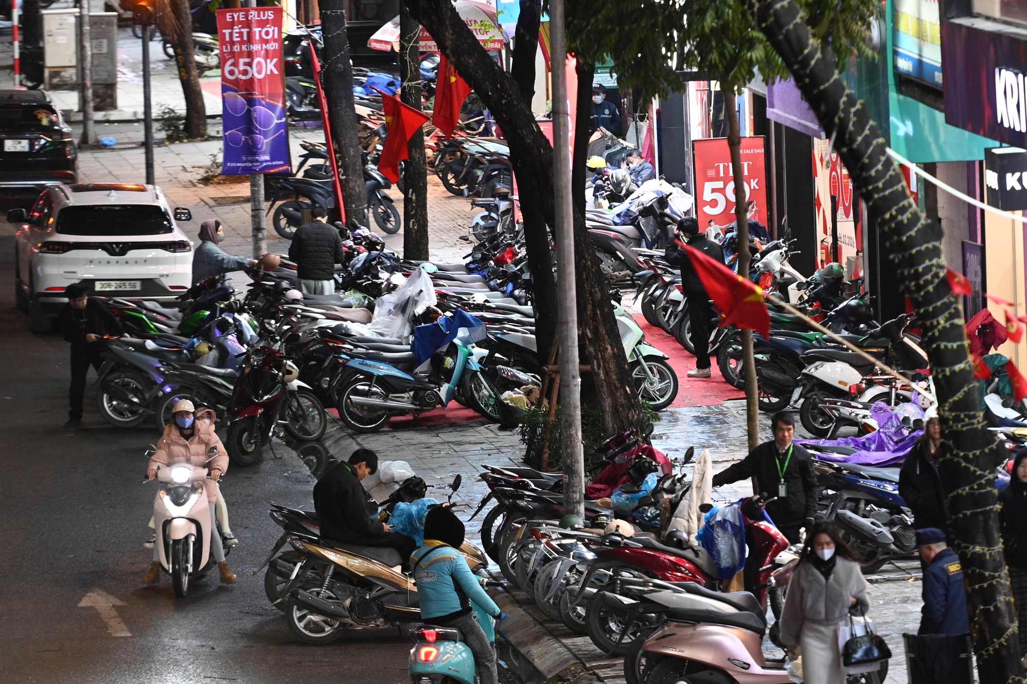 Cảnh tượng lạ trên phố Hà Nội tối mưa rét 10 độ, xe máy xếp chật kín vỉa hè- Ảnh 1.