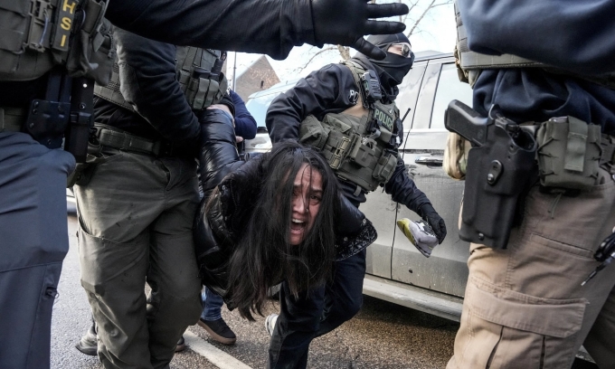 Đặc vụ liên bang áp giải một phụ nữ khỏi ôtô tại Minneapolis, Minnesota, ngày 13/1. Ảnh: Reuters