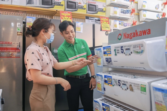 Nhân viên bán hàng đang tư vấn sản phẩm máy lạnh tại một cửa hàng điện máy. Ảnh: NAG