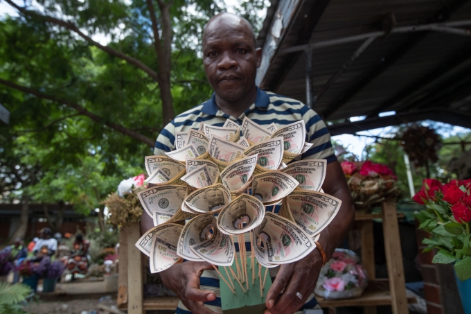 Florist Tongai Mufandaedza holds a money bouquet designed for Valentines Day at his stall in Harare, Zimbabwe, Tuesday, Feb. 10, 2026. (AP Photo/Aaron Ufumeli)