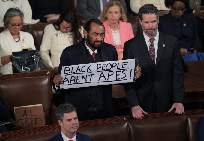 Nghị sĩ Al Green giơ tấm biển Người da đen không phải vượn trước khi ông Trump đọc Thông điệp Liên bang. Ảnh: AFP