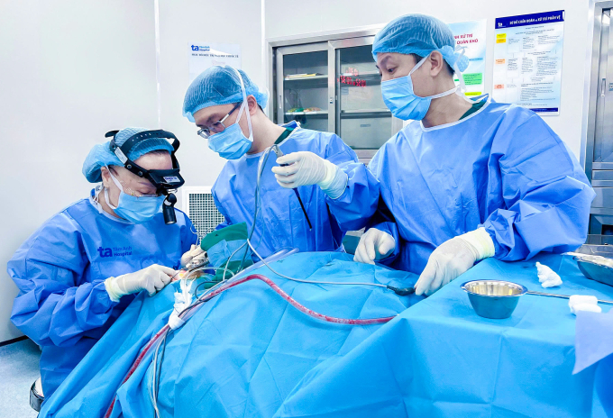 GS Chung Thủy (ngồi) đang phẫu thuật chỉnh hình họng, màn hầu lưỡi gà cho người bệnh. Ảnh: Bệnh viện Đa khoa Tâm Anh