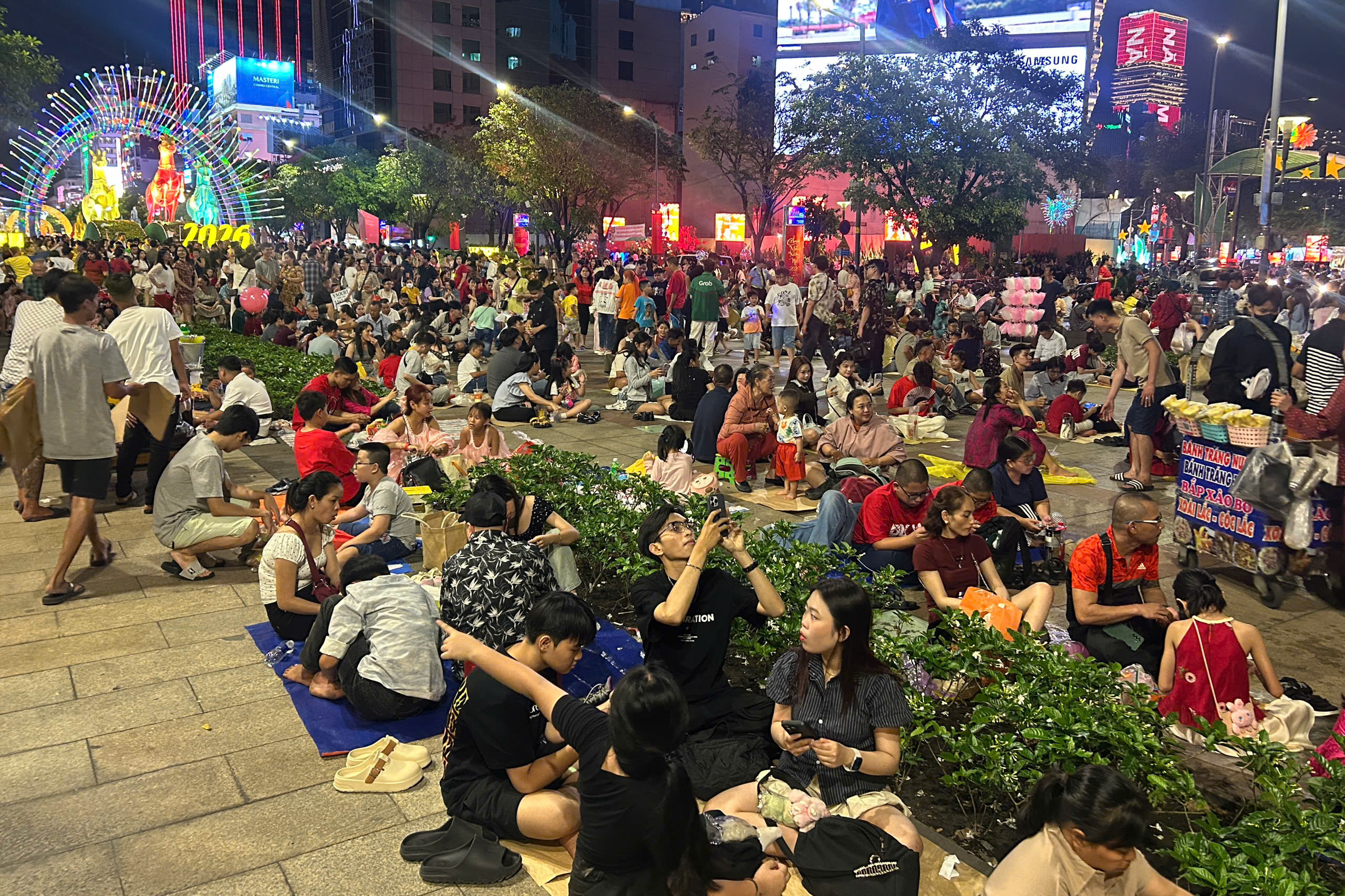 Người dân đổ về trung tâm vui chơi, nhiều nơi đã bắn pháo hoa sớm trước giao thừa - Ảnh 1.