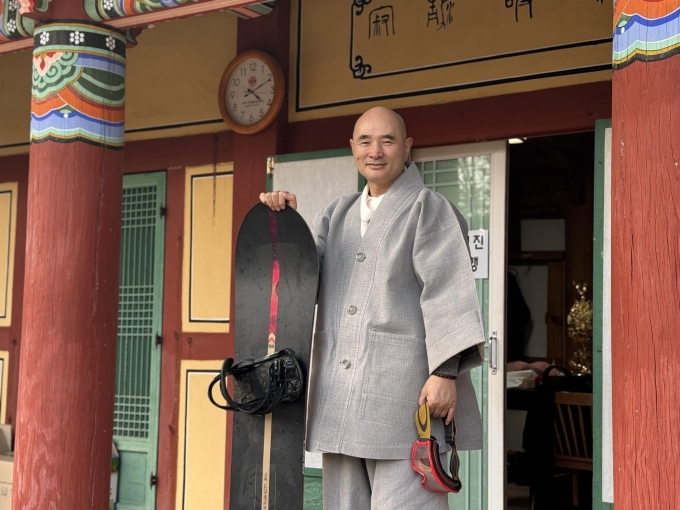 Ven. Hosan, abbot of Bongseon Temple and founder of the Dalma Open Championship, poses with his snowboard at the temple in Namyangju, Gyeonggi Province, Thursday. Yonhap
