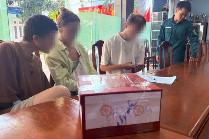 Nam thanh niên quốc tịch Đức (áo trắng) bị đưa về trụ sở Ban Chỉ huy quân sự phường An Hải làm việc. Ảnh: Ban Chỉ huy quân sự cung cấp