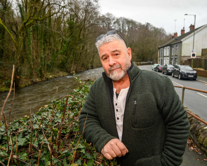 Ông Paul Thomas bên dòng Nant Clydach và khu phố Clydach Terrace. Ảnh: The Guardian