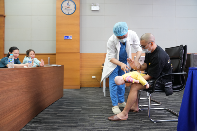 Bác sĩ Bệnh viện Đa khoa Tâm Anh Hà Nội đang hướng dẫn một phụ huynh sơ cứu trẻ bị hóc dị vật. Ảnh: Bệnh viện cung cấp