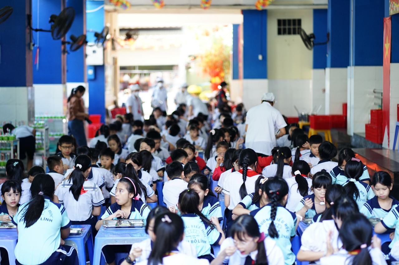 Cảnh tượng lạ tại cổng trường tiểu học ở TP.HCM mỗi buổi trưa: Phụ huynh tay xách cơm, người chờ đón con về nhà- Ảnh 1.