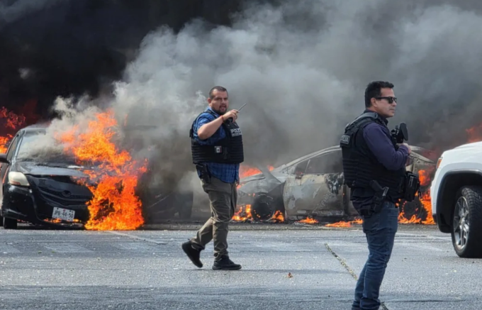 Lực lượng an ninh Mexico triển khai ứng phó bạo lực băng đảng, sau khi hàng chục ôtô bị phóng hỏa để dựng chướng ngại vật trên đường. Ảnh: Reuters