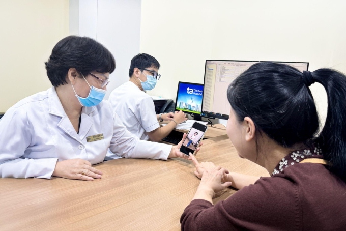 Chị Nhi tái khám và khoe hình con gái với bác sĩ Dung. Ảnh: Tuệ Diễm