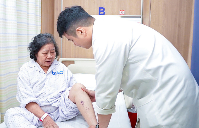 Bác sĩ Ân kiểm tra tình trạng chức năng khớp gối bà Mai trước mổ. Ảnh: Bệnh viện Đa khoa Tâm Anh