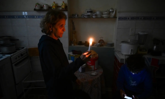 Người phụ nữ đốt nến khi nhà bị mất điện ở thủ đô Havana, Cuba, hôm 28/1. Ảnh: AFP