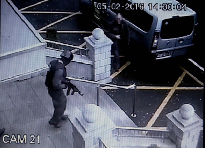 Tay súng cải trang thành cảnh sát cầm AK47 tẩu thoát khỏi khách sạn. Ảnh: Sun