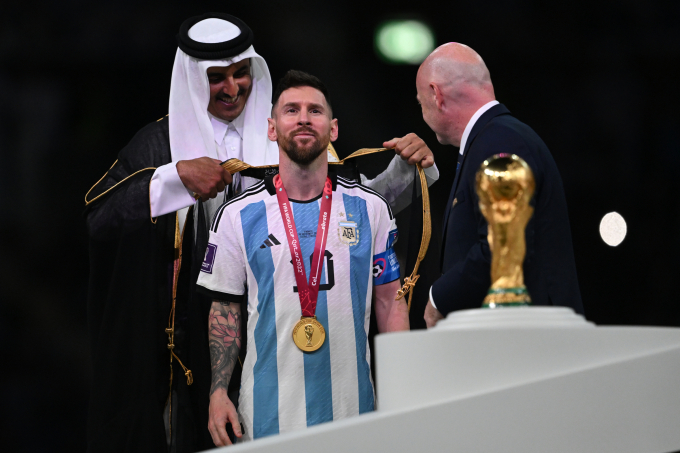Tiểu vương Qatar (trái) khoác áo choàng Hồi giáo lên Messi sau khi Argentina vô địch World Cup 2022 ngày 18/12/2022. Ảnh: AFP