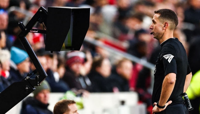 Trọng tài kiểm tra lại một tình huống sau khi VAR can thiệp tại Ngoại hạng Anh. Ảnh: AFP