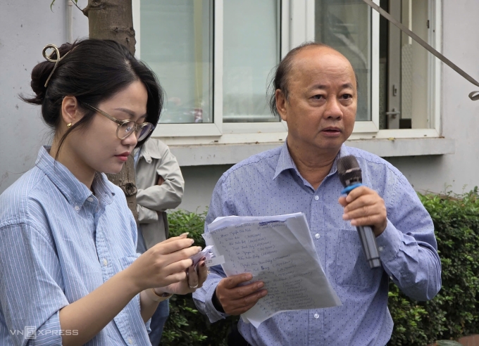 Hiệu trưởng Vũ Thành Thái đọc tên phụ huynh theo danh sách tự lập để phát số nộp hồ sơ. Ảnh: Thanh Hằng