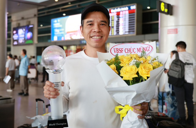 Quyết Chiến khoe chức vô địch billiards carom 3 băng đồng đội thế giới lần thứ hai trong sự nghiệp, tại sân bay Tân Sơn Nhất, chiều 3/3. Ảnh: Đức Đồng