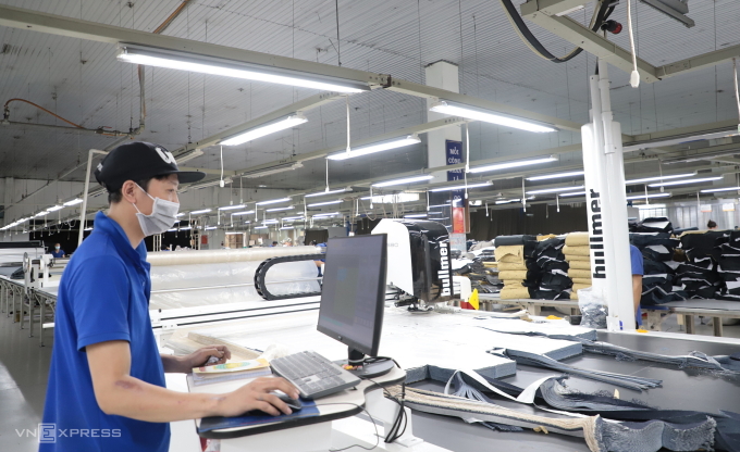 Công nhân điều khiển máy cắt tự động ở nhà máy PPJ-Wiser. Ảnh: Lê Tuyết