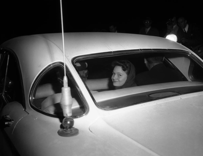 Caril Ann Fugate, 14 tuổi, nở nụ cười với các nhiếp ảnh gia từ ghế sau xe, ngày 31/1/1958. Ảnh: AP