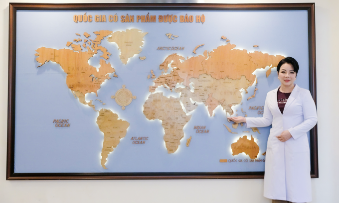 Bà Phạm Thị Kim Loan bên cạnh bản đồ nơi có các sáng chế và sản phẩm có sáng chế của bà được bảo hộ.