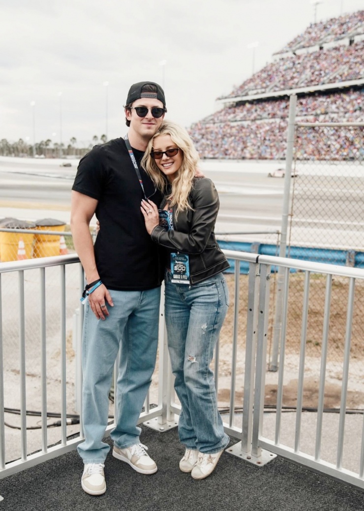 Bạn trai song hành Lindsay Brewer ở chặng đua Daytona International Speedway, hôm 16/2. Nhiều fan đánh giá Drew Solomon năng động với kiểu phối áo thun, quần jeans, giày thể thao và mốt đội mũ ngược. Lindsay Brewer diện phong cách tương tự, tạo khác biệt với áo khoác da.