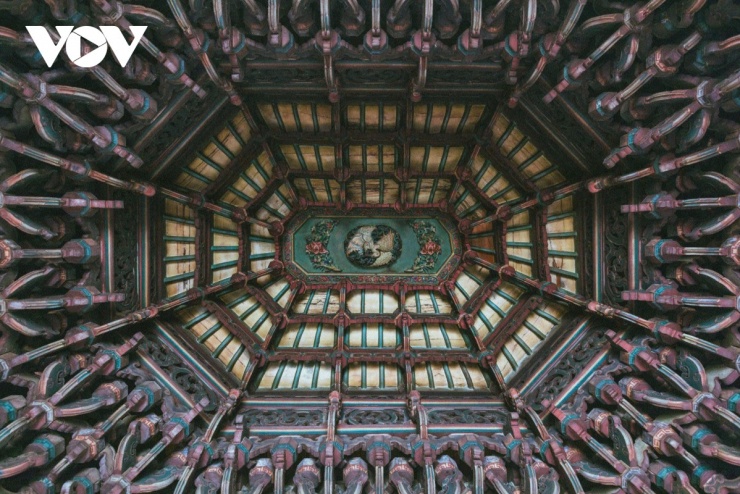 Trần nhà bát giác được trang trí cầu kỳ, trong khi lối đi trung tâm nổi bật với những bức chạm đá trắng mô tả hình ảnh “song long tranh châu” – hai con rồng hướng về viên ngọc thiêng.