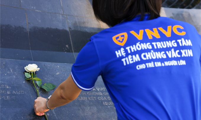 Cán bộ nhân viên Hệ thống Tiêm chủng VNVC dâng hoa tưởng niệm đồng bào, cán bộ, chiến sĩ đã mất trong đại dịch Covid-19 tại Tượng đài Giọt nước mắt, TP HCM. Ảnh: Nhân Lê