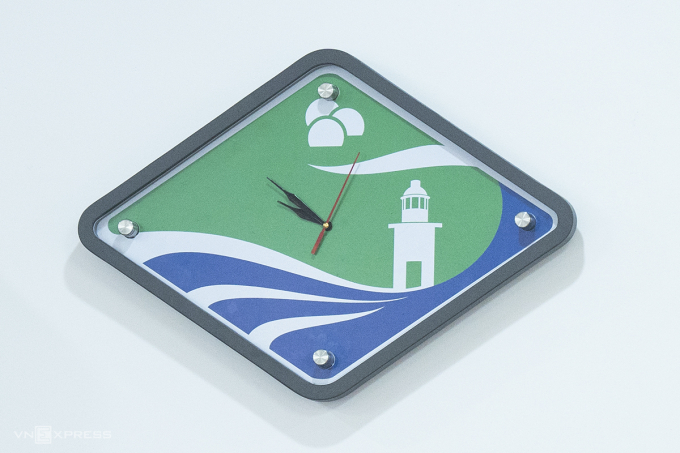 Logo biểu trưng của phường Sơn Trà với rừng, biển, ngọn hải đăng, trạm radar đã được ứng dụng vào nhiều vật dụng, trong đó có chiếc đồng hồ treo tại hội trường UBND phường. Ảnh: Nguyễn Đông