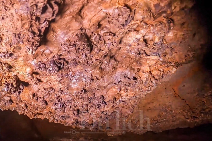 Dưới ánh sáng trắng nhờ từ đèn pin chiếu rọi, đập vào vách đá hiện lên sắc màu đỏ quạch, bàng bạc lấp loáng, tất cả hiện ra kỳ ảo, vừa hư vừa thực.