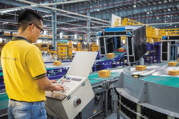 Kỹ sư vận hành hệ thống phân loại hàng hóa trong một trung tâm chia chọn của Vietnam Post. Ảnh: Quốc Bảo